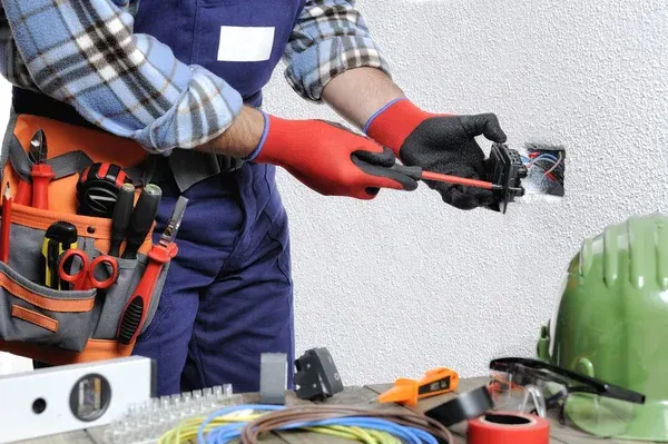 Electricista instalando cableado en una caja eléctrica
